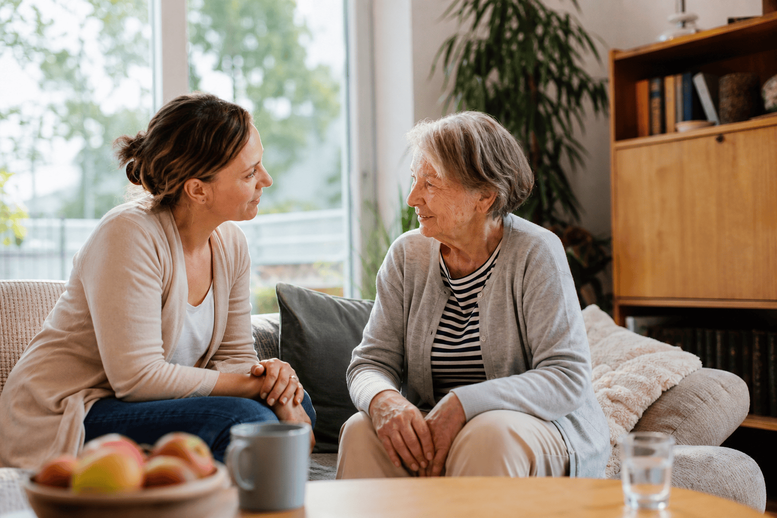 Ältere Person und Angehöriger sprechen über Unterstützung im Alltag