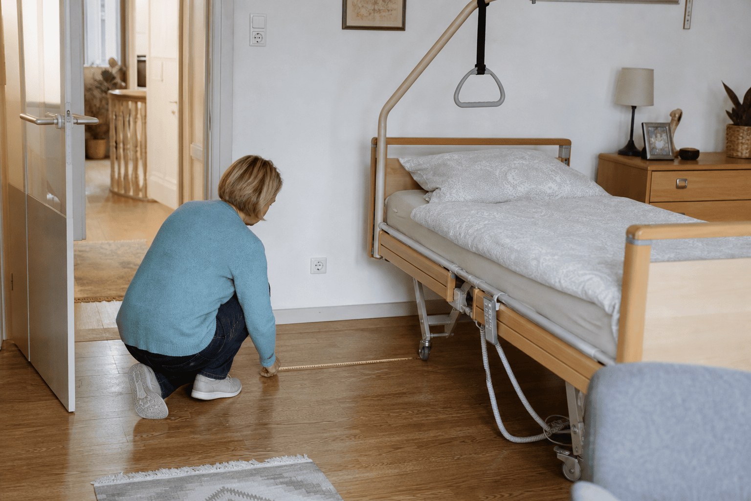 Angehörige prüft den Platz neben einem Pflegebett im Schlafzimmer